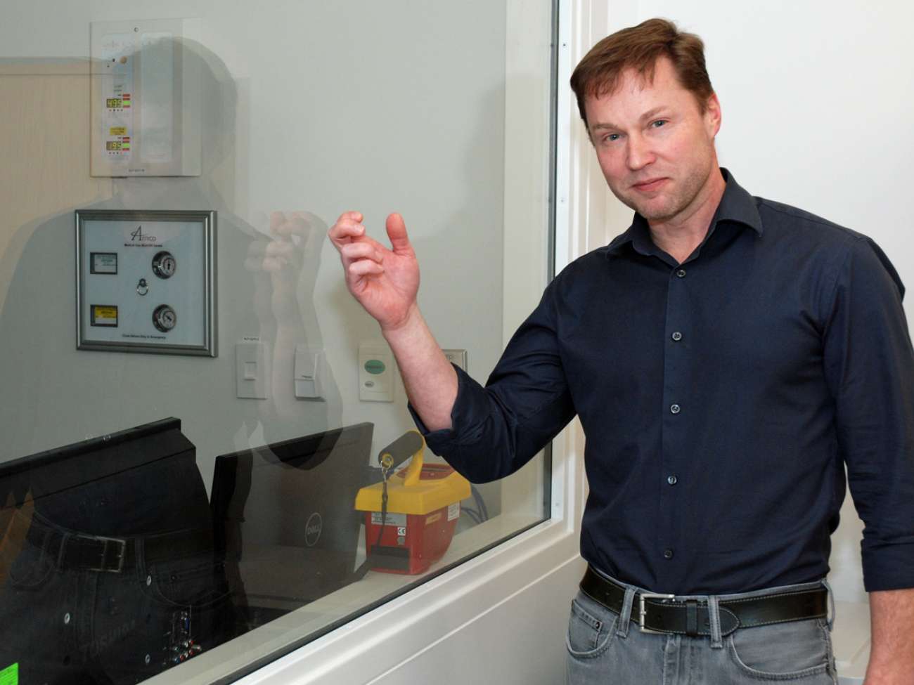 No ordinary glass: Medical physicist Andre Fleck shows the lead-infused glass separating the control and treatment rooms in the orthovoltage suite. Lead in glass, walls and doors keeps the risk of radiation exposure negligible.