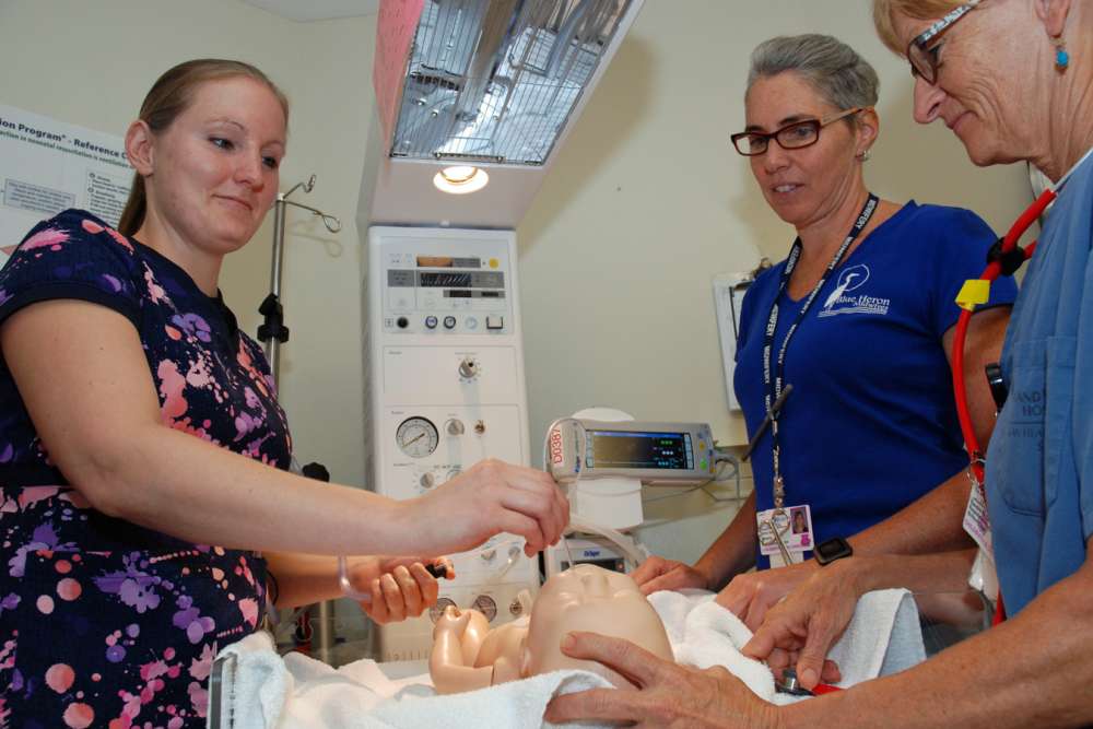 A team practices their neonatal resuscitation skills in GRH's childbirth program.