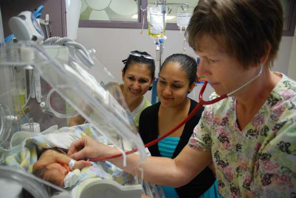 A photo of a family and a nurse in the NICU with a baby