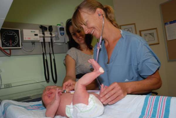 A photo of a care provider checking a baby