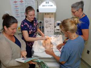 Sheri Douglas coaches a team as they practice their neonatal resuscitation skills