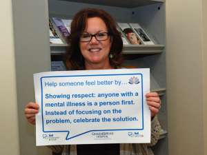 Sue's sign reads: help someone feel better by showing respect: anyone with a mental illness is a person first. Instead of focusing on the problem, celebrate the solution.