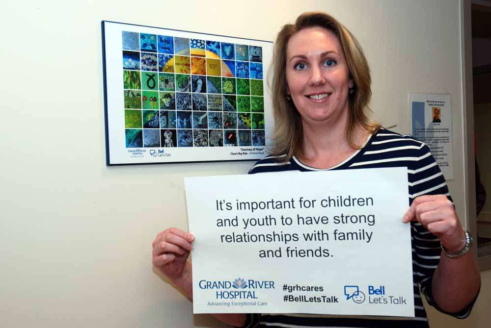 A care provider with a poster reading: It’s important for children and youth to have strong relationships with family and friends.