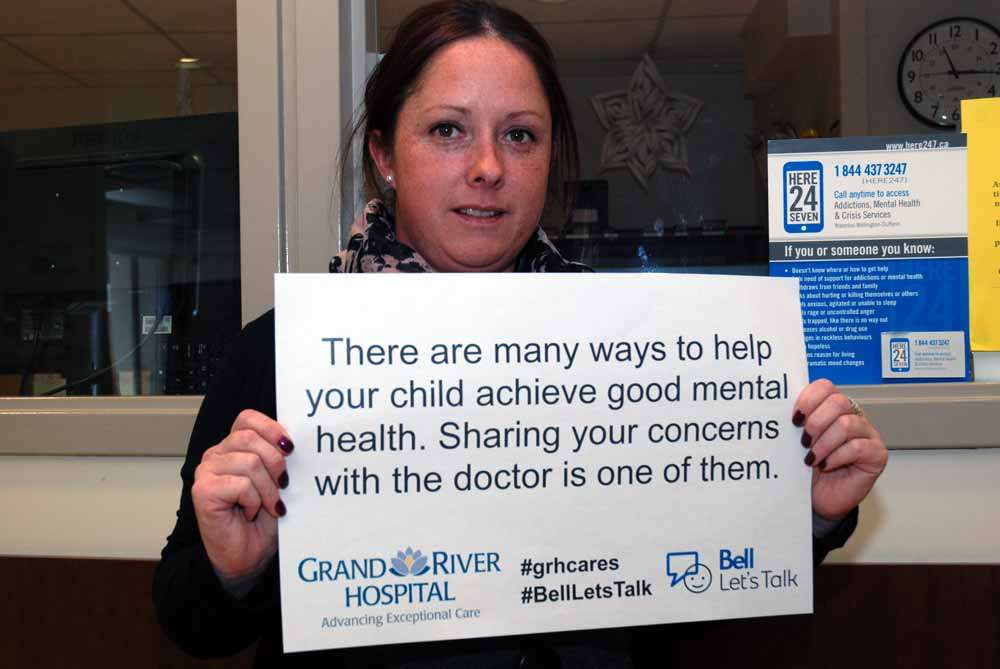 A care provider holding a sign reading: There are many ways to help your child achieve good mental health. Sharing your concerns with the doctor is one of them.