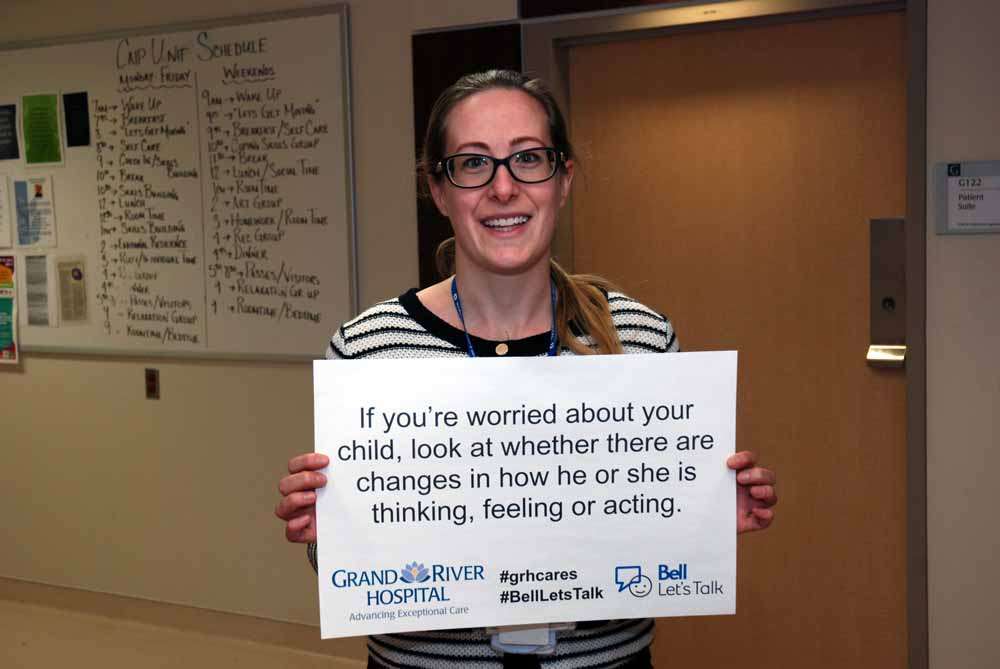 A care provider holding a sign reading: If you’re worried about your child, look at whether there are changes in how he or she is thinking, feeling or acting.