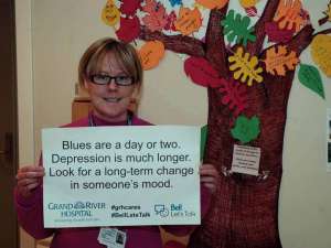 A care provider with a sign reading: Blues are a day or two. Depression is much longer. Look for a long-term change in someone's mood.