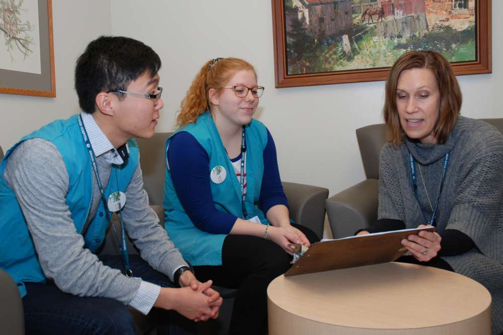 Marsha plans upcoming patient visits with volunteers Kunpei and Katie.