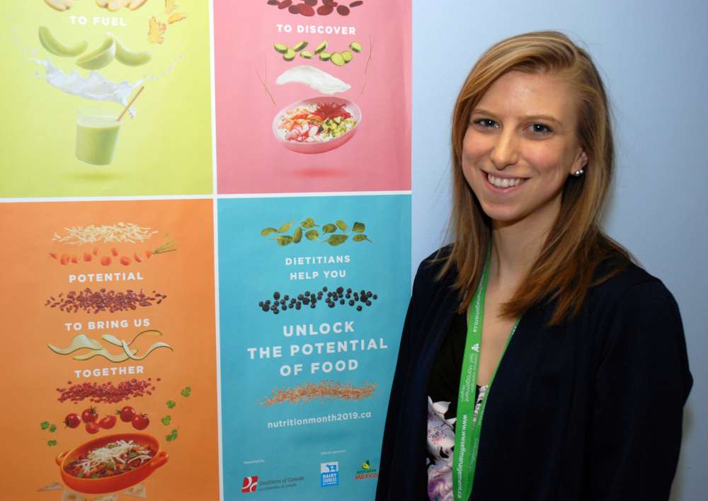 Melanie Thuss with a poster of food images
