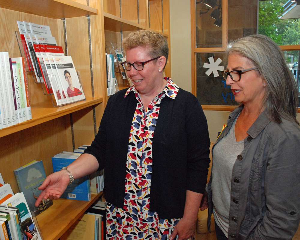 Two women looking at books instead the resource centre