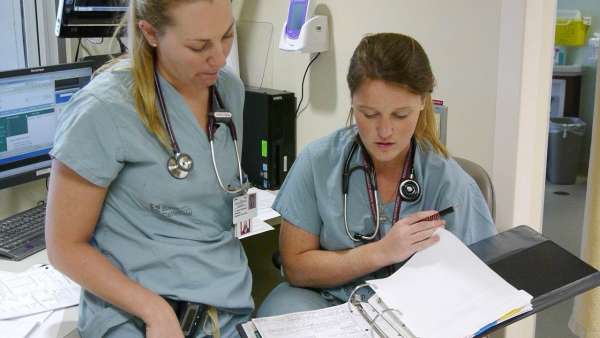 A photo of two resident physicians in the ICU