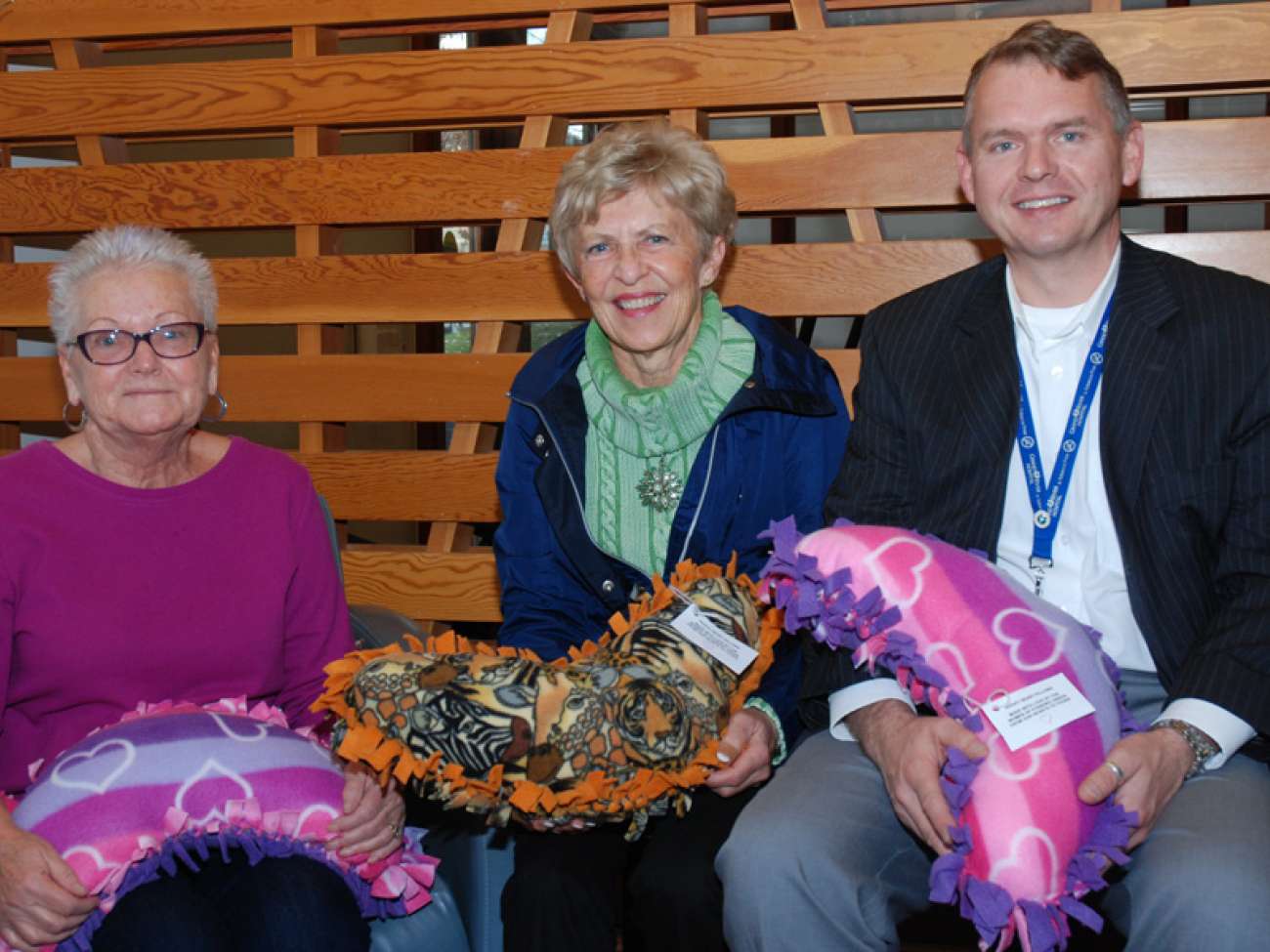 Shirley Chapman (centre) from the community of Foxboro Green drops off the latest donation of huggy pillows to patient Hildegard Anderson (left) and GRH's Owen Roszell (right)
