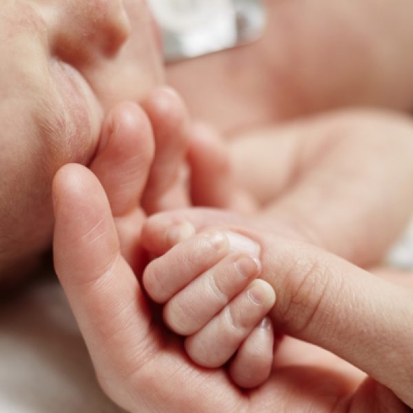 A nurse holding a baby's hand