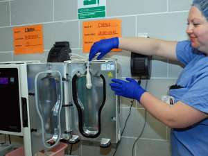 Medical device reprocessing manager Lisa McBriarty demonstrates how the probe is placed in the unit for disinfection.