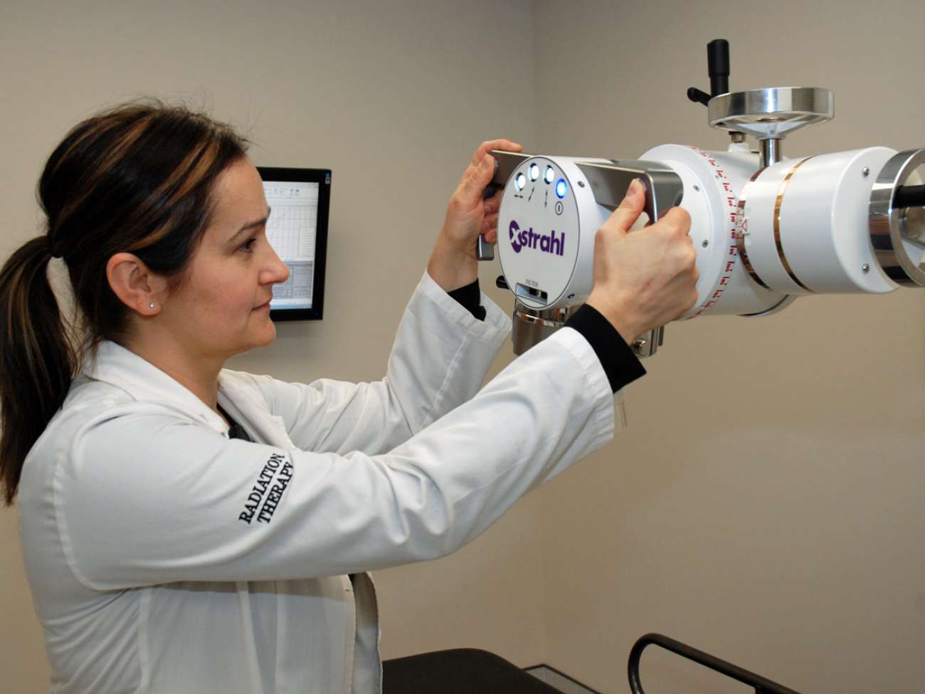 Radiation therapist Andrea Tonin positions the new orthovoltage unit to provide care for a patient.