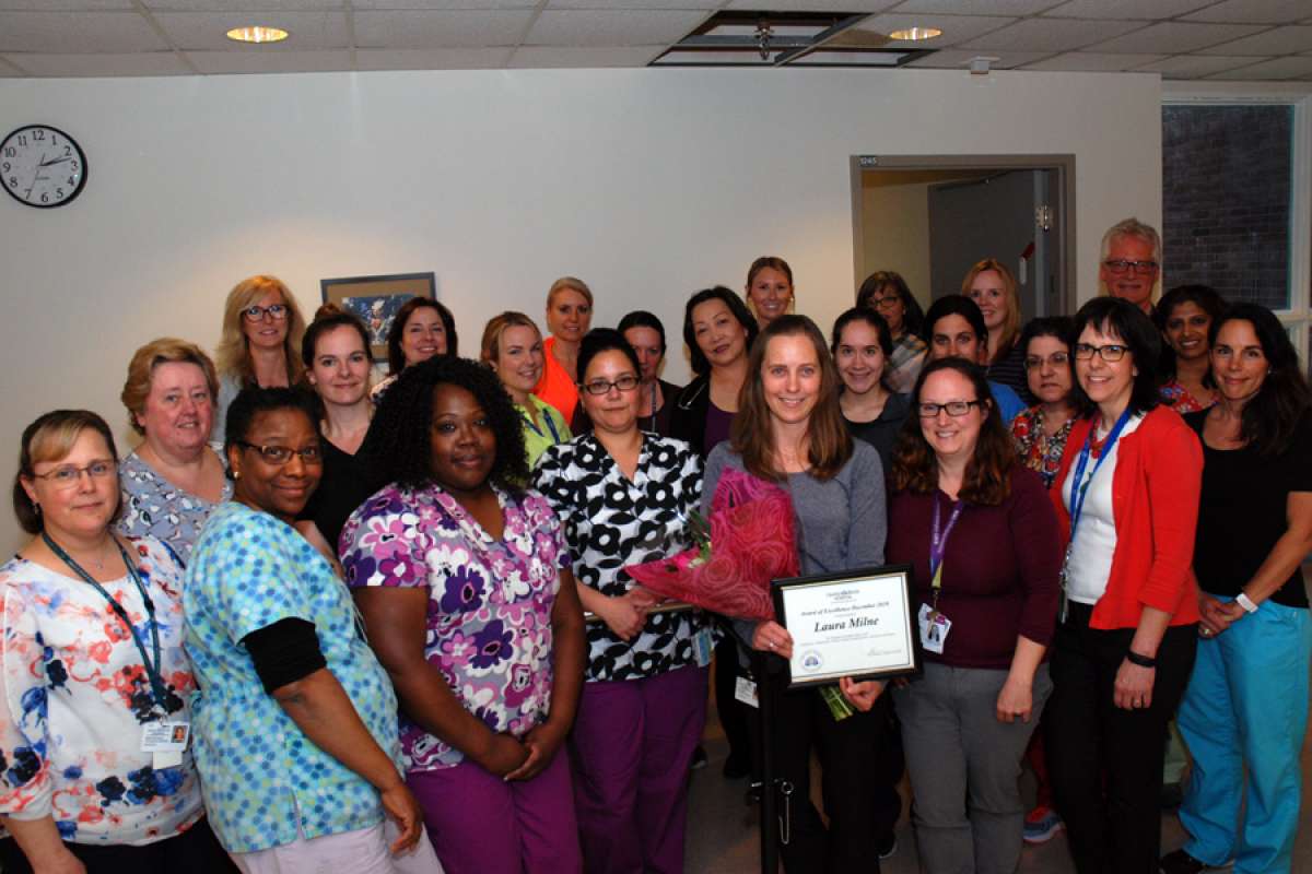 Laura Milne's colleagues gather to congratulate her award of excellence win.