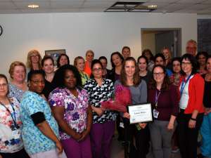 Laura Milne's colleagues gather to congratulate her award of excellence win.