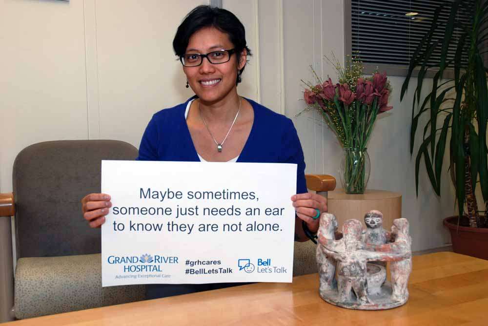 A care provider holding a sign reading: Maybe sometimes someone just needs an ear to know they are not alone.