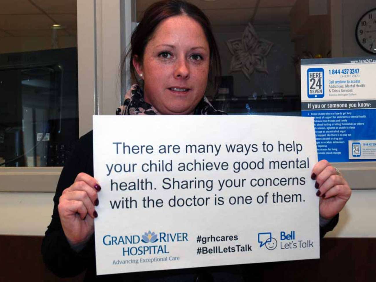 A care provider holding a sign reading: There are many ways to help your child achieve good mental health. Sharing your concerns with the doctor is one of them.