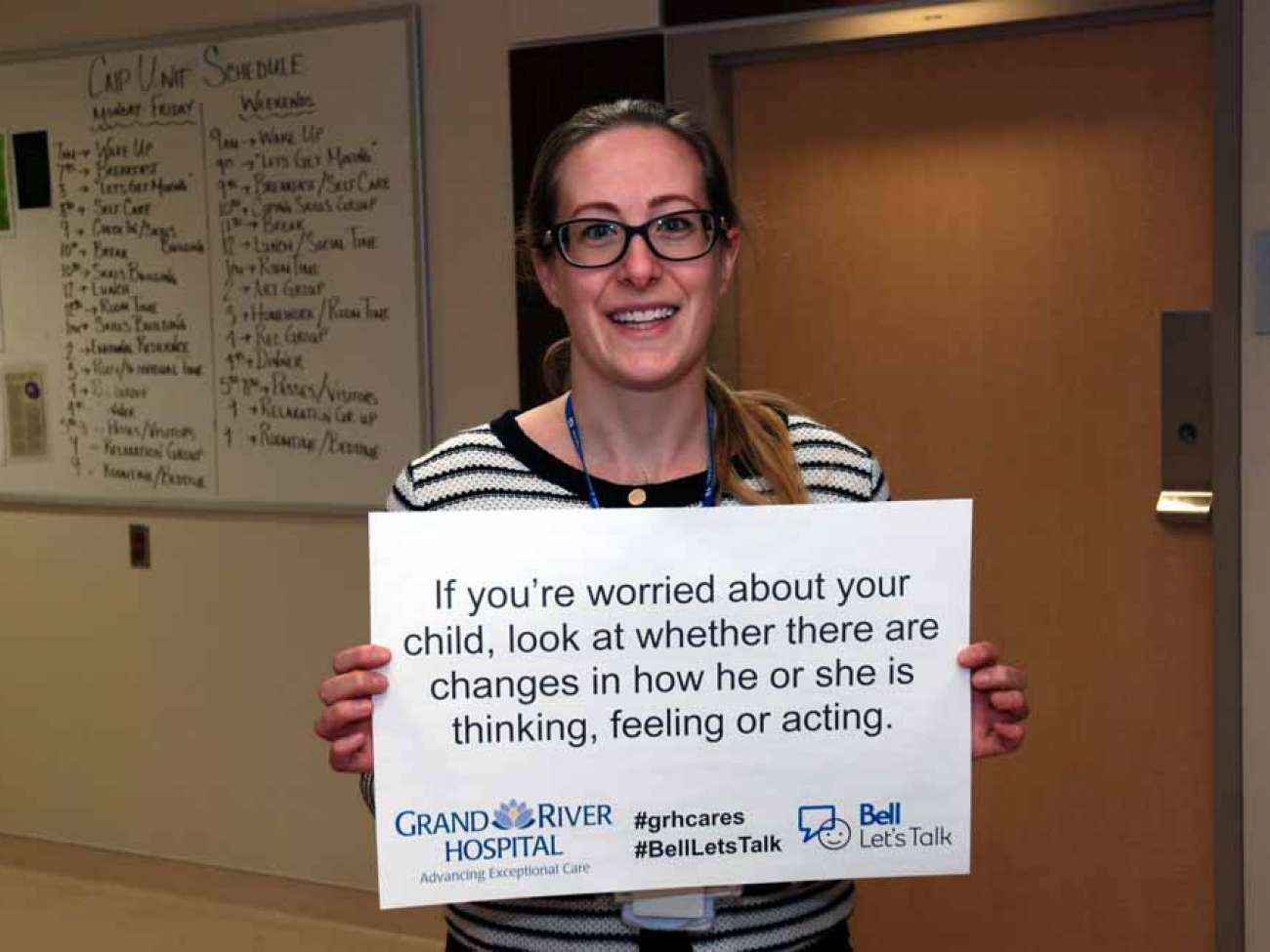 A care provider holding a sign reading: If you’re worried about your child, look at whether there are changes in how he or she is thinking, feeling or acting.