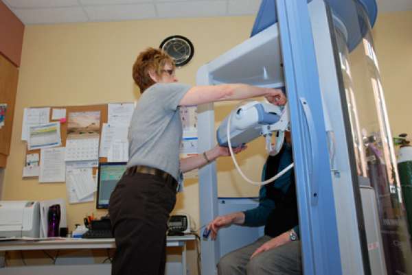 A care provider assisting a patient during a pulmonary function test