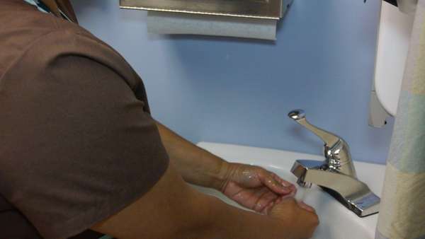 A photo of a health provider washing her hands.