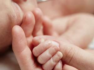 A nurse holding a baby's hand