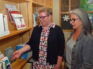 Two women looking at books instead the resource centre