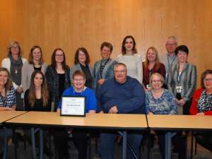 Sue Rueckwald's colleagues join her as she receives her award of excellence.