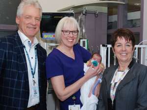 Brenda Menard stands with GRH CEO Ron Gagnon, VP Judy Linton and a young patient in the NICU